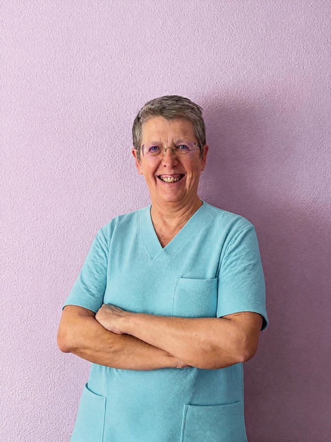 La Dra. Nuria Francés, médica y odontóloga, sonriendo con los brazos cruzados